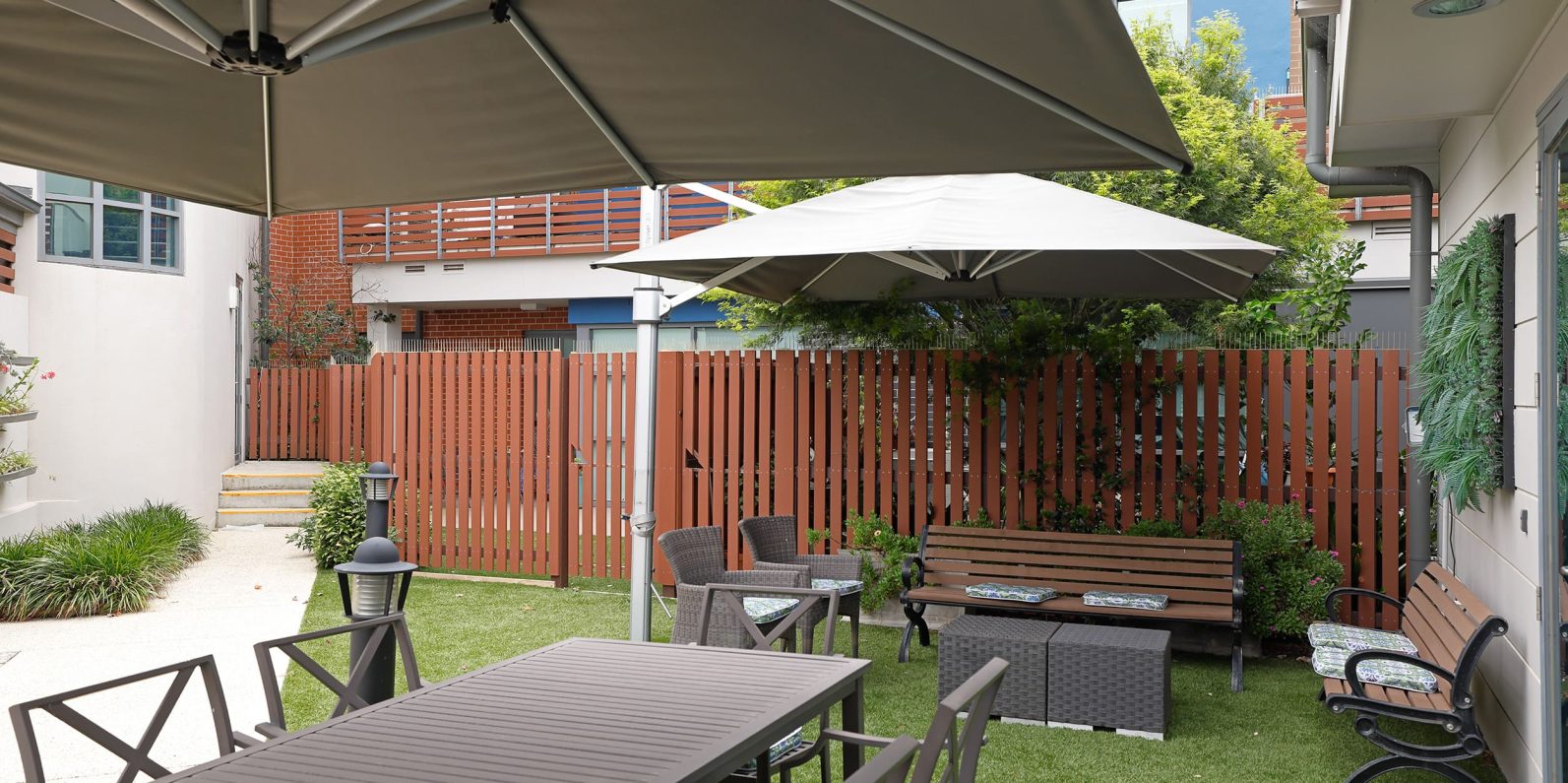 Amarco courtyard with outdoor seating, tables and umbrellas.