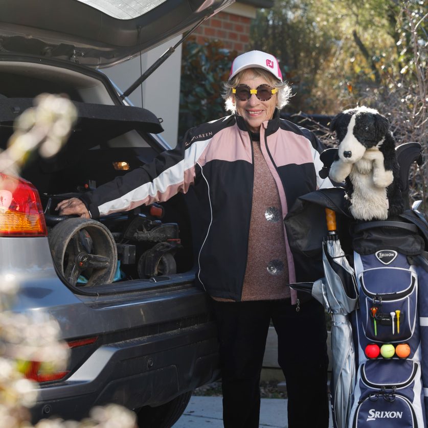Respite care customer is pictured at their car with gold equipment.