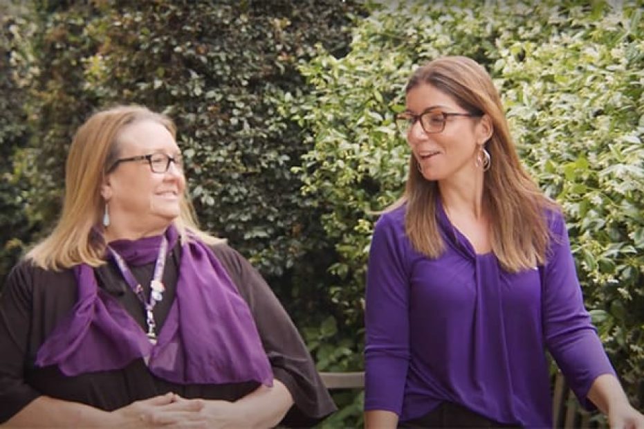 Two people walking and talking together.