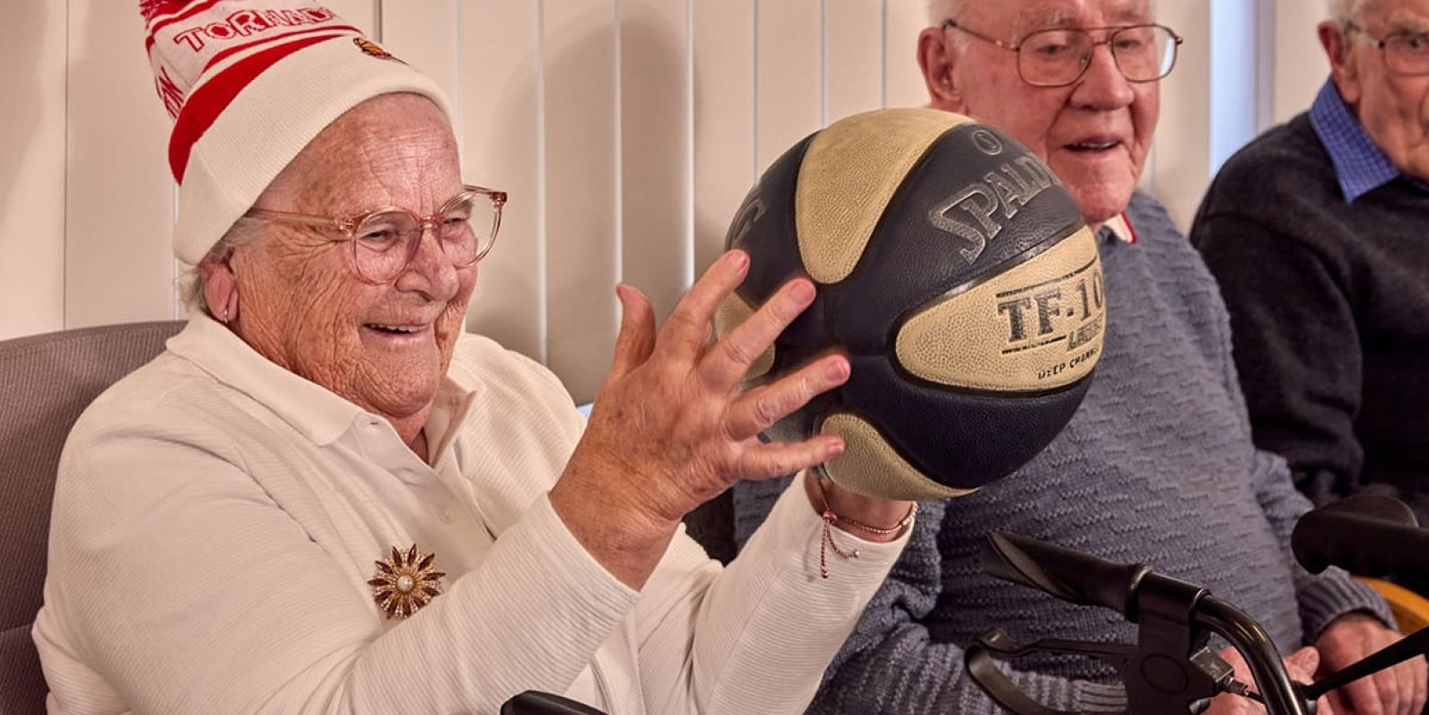 Person holding basketball smiling.