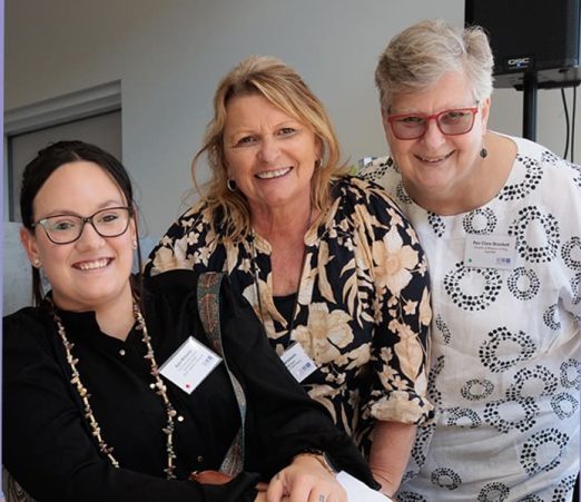 Portrait of three people smiling.