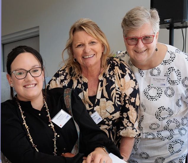 Portrait of three people smiling.
