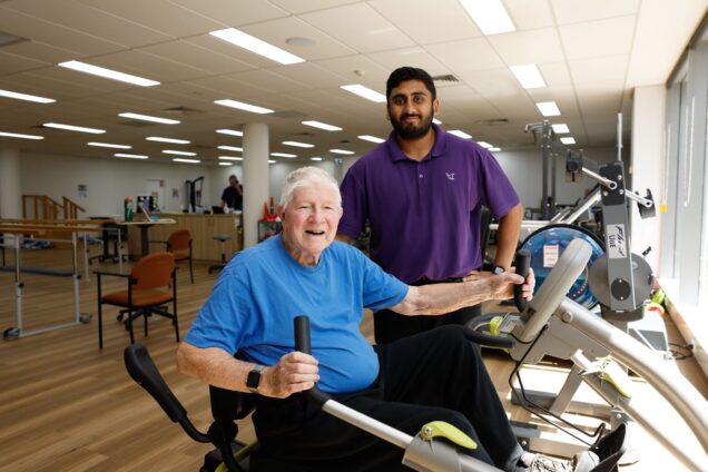 Customer exercising at a Uniting AgeWell Community Hub w standing next the them with a staff member