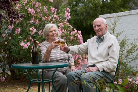 Couple photographed in the garden having a drink
