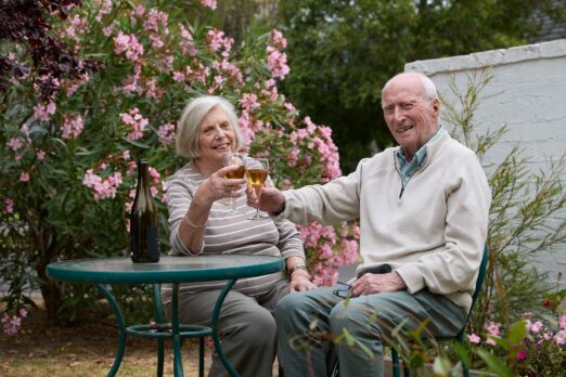 Couple photographed in the garden having a drink