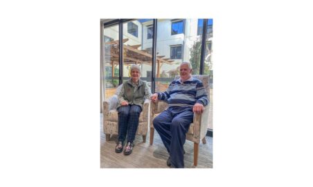 Hawthorn Community residents, Alan and Joan, are photographed sitting together, holding hands