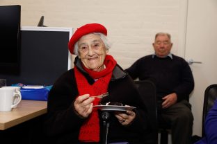 A person wearing a red hat is smiling at the camera.