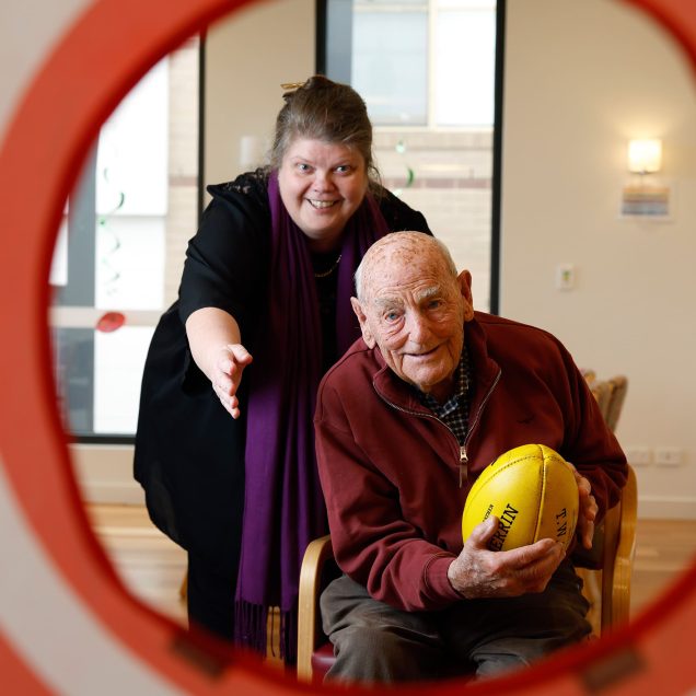 Customers and carer are pictured playing football